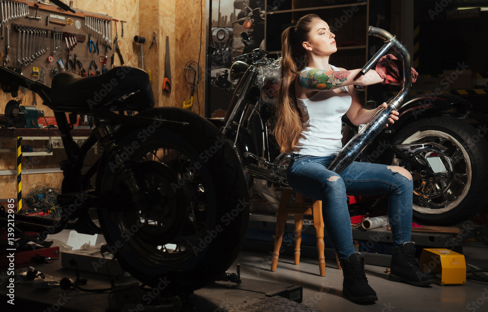 Beautiful sporty girl looking at exhaust pipe