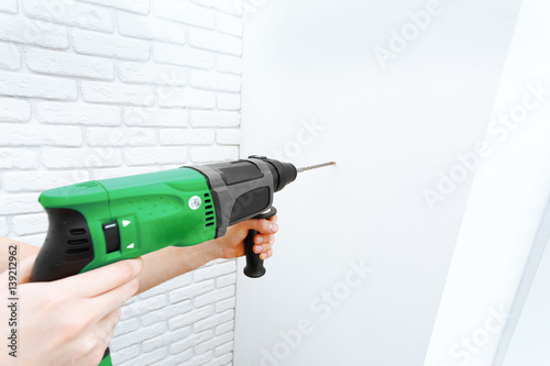 Use hammer drill to drill the wall