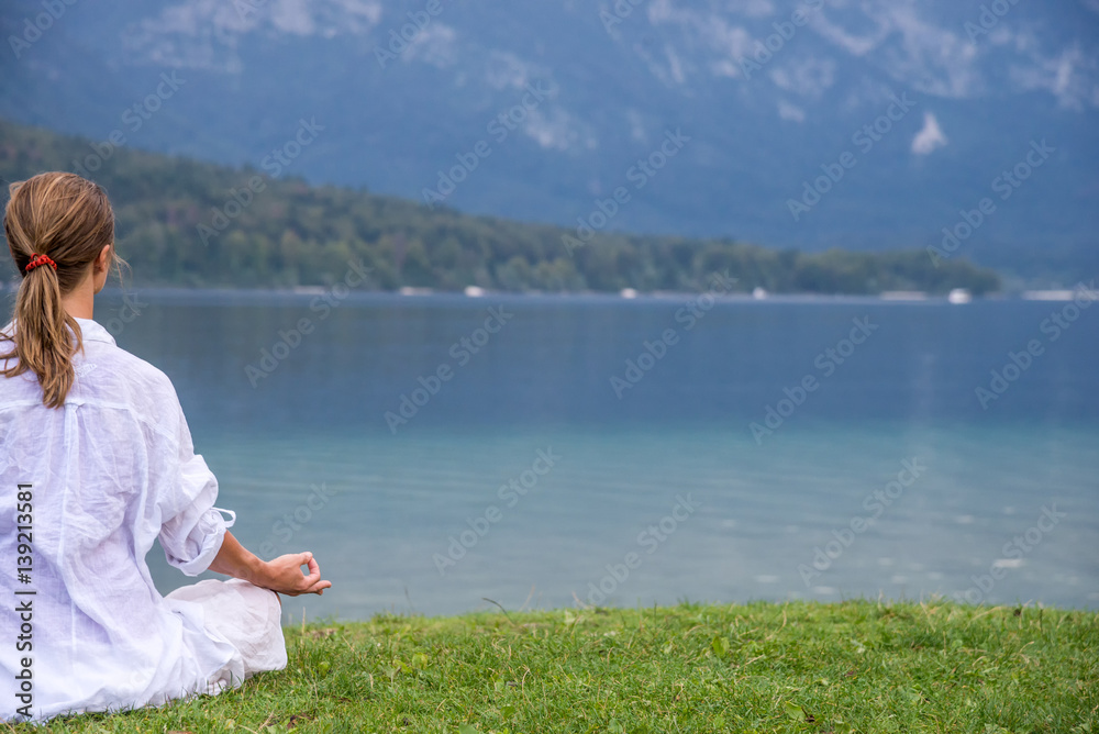 Fototapeta premium Woman meditating at the lake