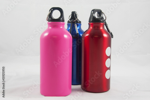 three multi colored metallic bottles 