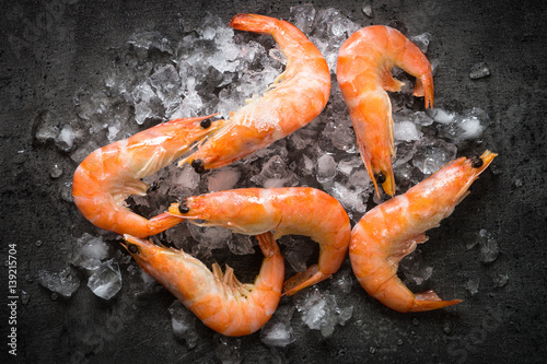 Fresh Prawns Shrimps on ice. Top view black slate table