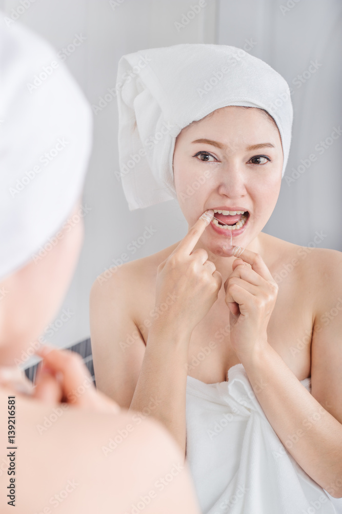 woman use dental floss white healthy with mirror in bathroom woman use dental floss white healthy with mirror in bathroom