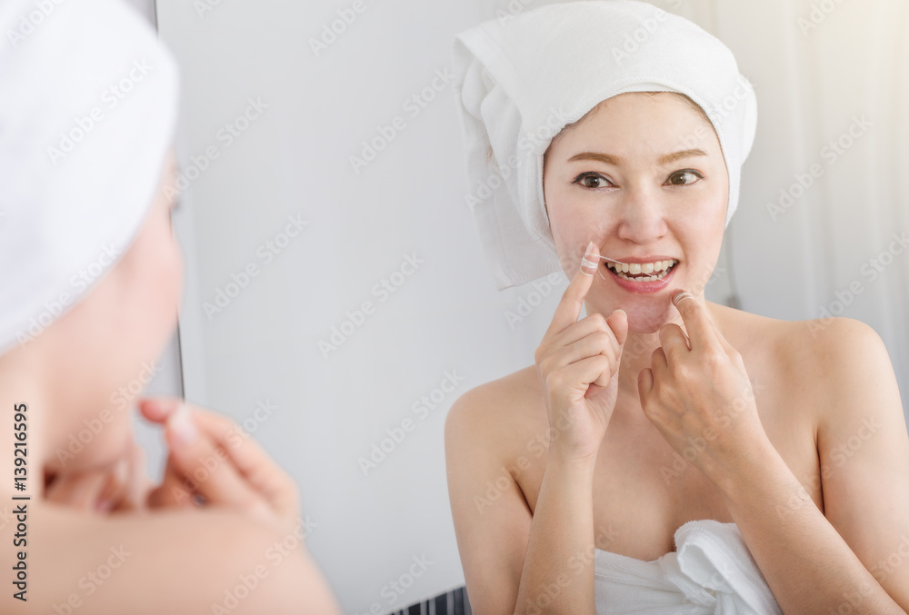 woman use dental floss white healthy with mirror in bathroom woman use dental floss white healthy with mirror in bathroom