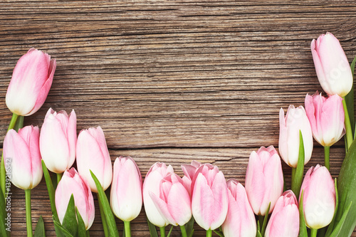 Fototapeta Naklejka Na Ścianę i Meble -  Pink tulips on  wooden background. Top view, copy space