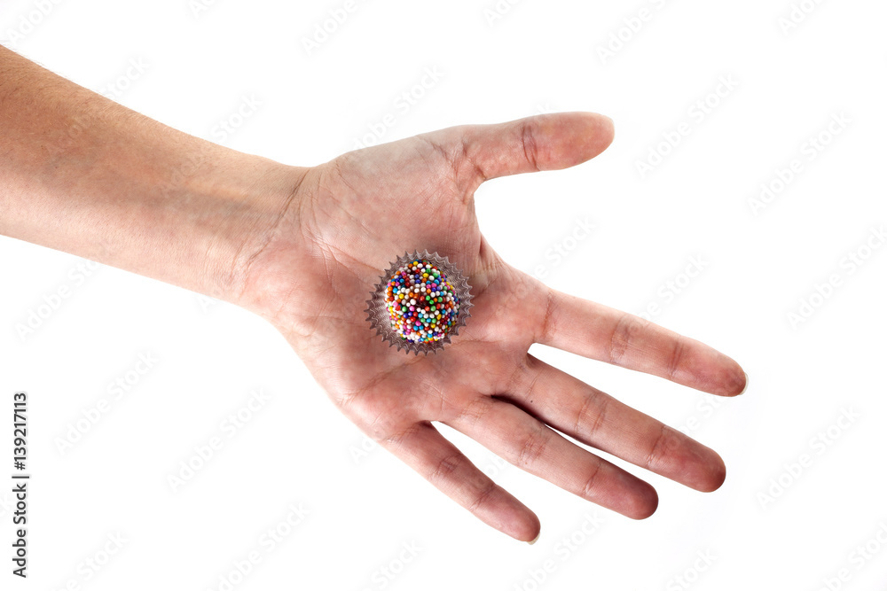 Hand holding a traditional candy from Brazil called brigadeiro over white background Hand holding a traditional candy from Brazil called brigadeiro over white background