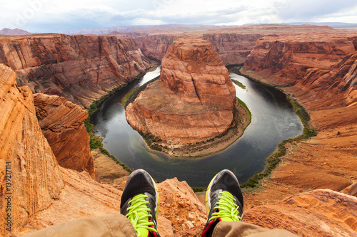 Legs of traveler man sitting on the background of the canyon Horseshoe bend, Arizona, USA. Travel concept, scenic view photo