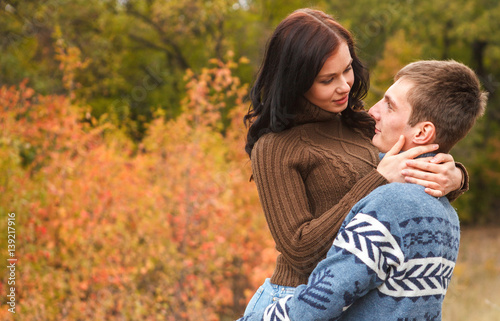 girl at the hands of Man. A loving couple walking in the autumn park.