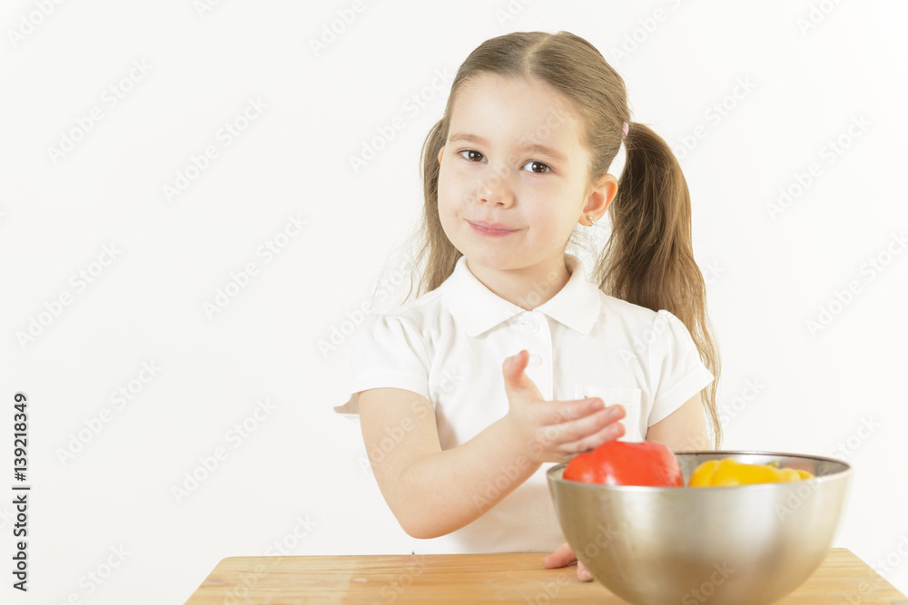 Cute little girl cooking. Child showing a bowl with different colors of bell pepper. Healthy food, cooking salad with vegetables ingredients. Recipe. Nutrition. Healthy food concept. Cute little girl cooking. Child showing a bowl with different colors of bell pepper. Healthy food, cooking salad with vegetables ingredients. Recipe. Nutrition. Healthy food concept.