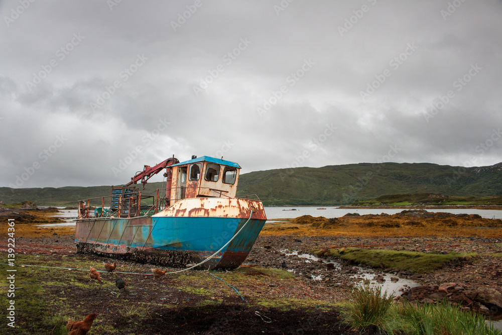 Rusty fishing boat at low water