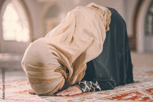 Muslim woman prostration while praying photo