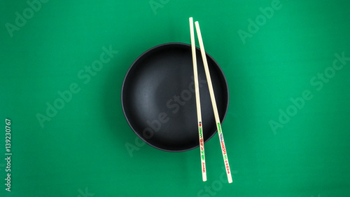 Black Japanese soup bowls with chopsticks.and green background