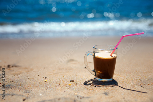 iced coffee latte on a beach ocean and seascape, shallow dof