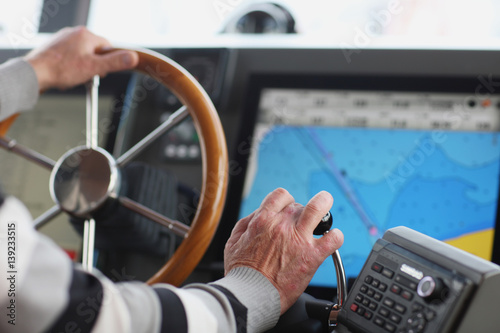 The hands of the captain and a steering wheel boat port services