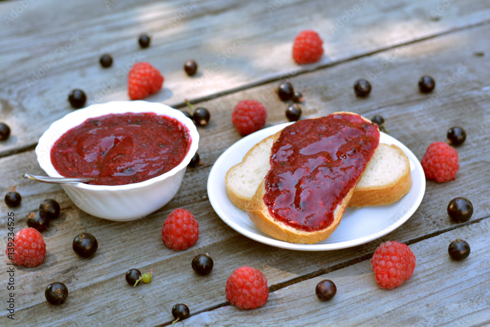 Sandwich with mixed, fragrant, blackcurrant raspberry jam on wooden background - healthy, summer refreshment Sandwich with mixed, fragrant, blackcurrant raspberry jam on wooden background - healthy, summer refreshment