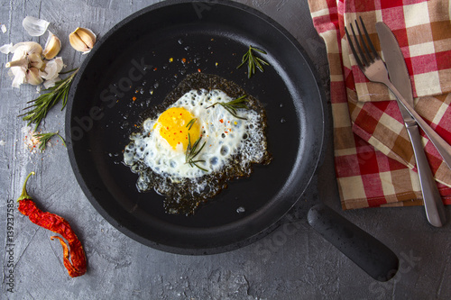 fried eggs iron frying pan rosemary spice pepper 