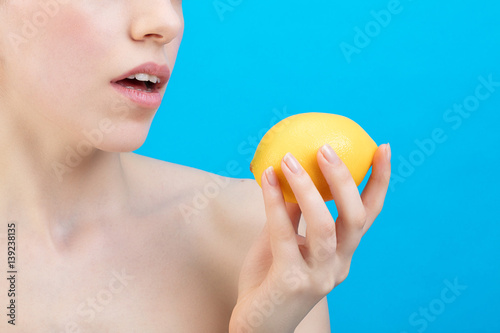 Portrait d'une jeune femme tenant un citron dans sa main 