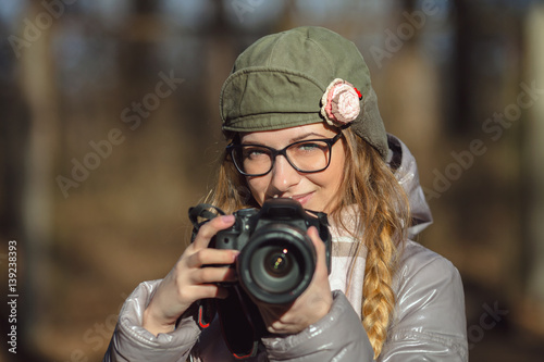 Young european woman photographer enjoying first spring sun exploring suburban locations © sergeyzapotylok