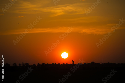 Sunset with sun and clouds in orange and golden light © Vero