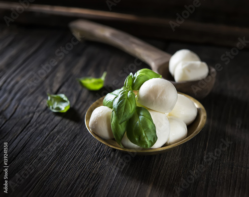 mini mozzarella and basil on a wooden background