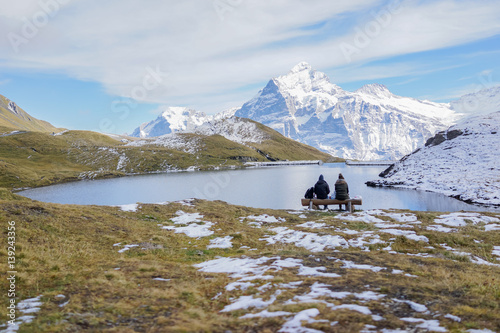 Couple resting and looking at Bachsee, Alps, Switzerland autumn photo