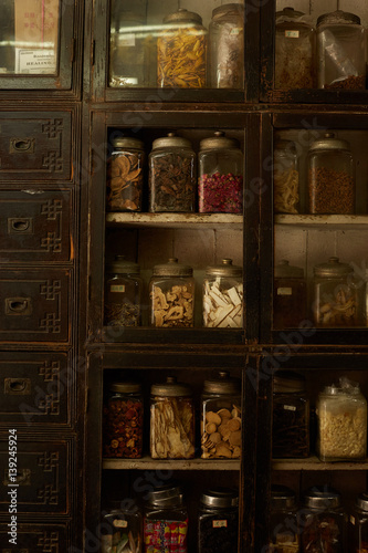 Glass jars on shelves with traditional Chinese herbal medicine