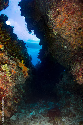 A dive boat on the surface above a large underwater canyon