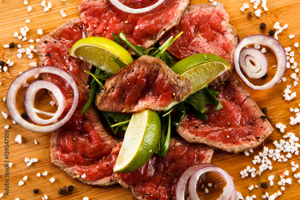 Carpaccio steaks on wooden board Stock Photo Adobe Stock