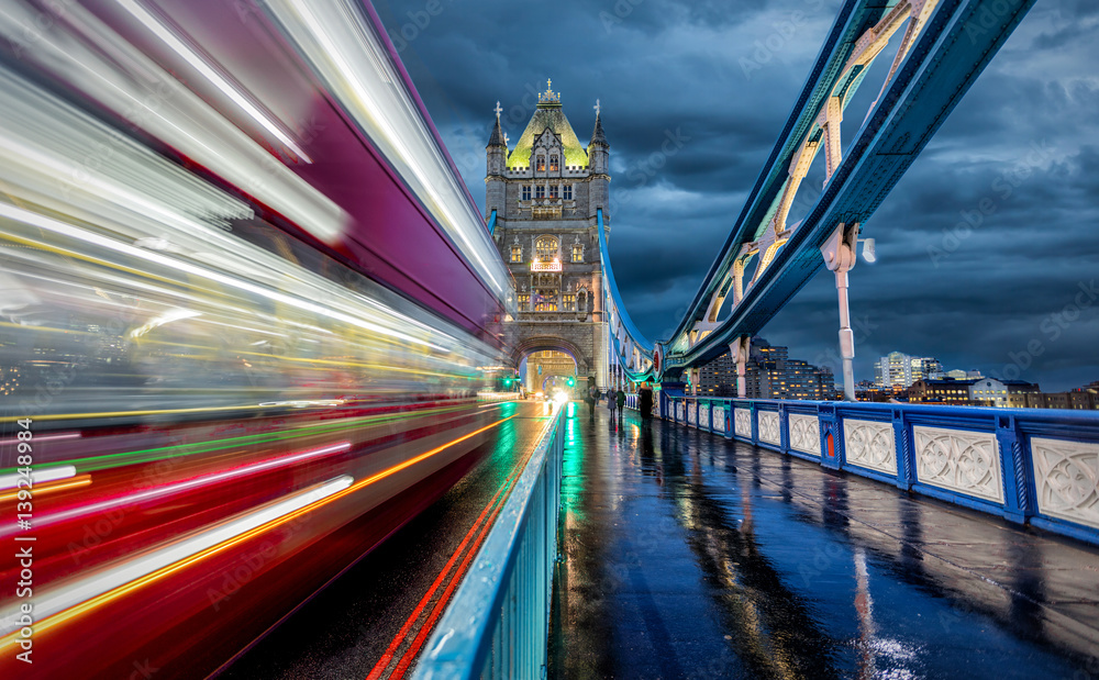 Obraz premium Abends auf der Tower Bridge in London bei Regen mit rotem Bus