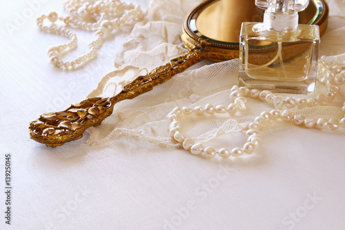 white lace fabric, perfume, mirror and white flowers