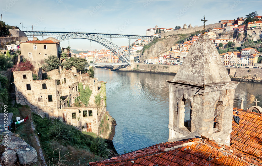 Porto slums, view on Dom Luís I Bridge. Abandoned buildings church and river. Non-touristic wild place. Alternative route.