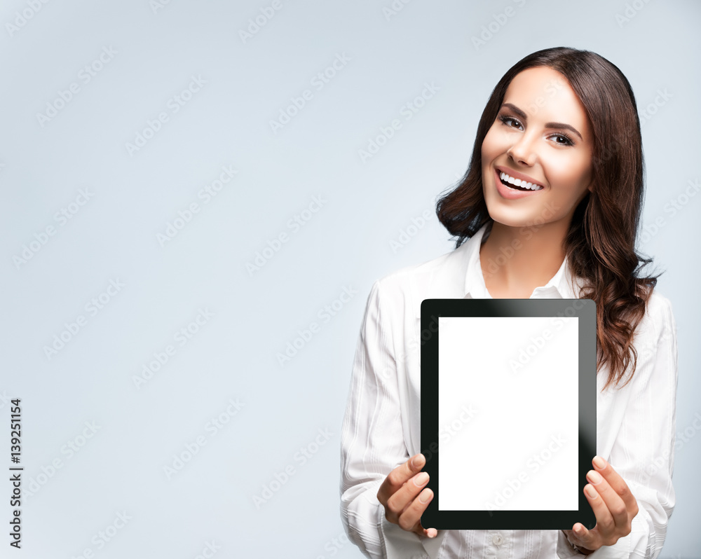 Businesswoman showing blank tablet pc, on grey