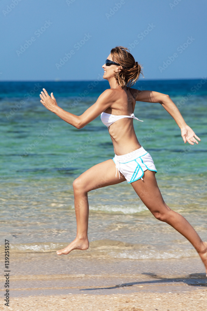 femme souriant qui court sur une belle plage femme souriant qui court sur une belle plage