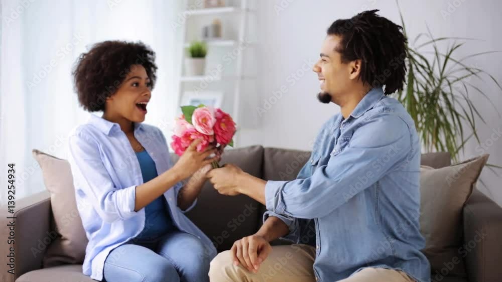 happy couple with bunch of flowers at home happy couple with bunch of flowers at home