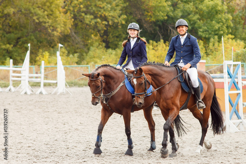 Young man and woman riding bay horses on equestrian competiton © skumer