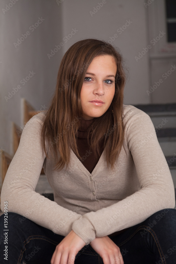 Sexy girl looking at camera sitting on steps indoors Sexy girl looking at camera sitting on steps indoors