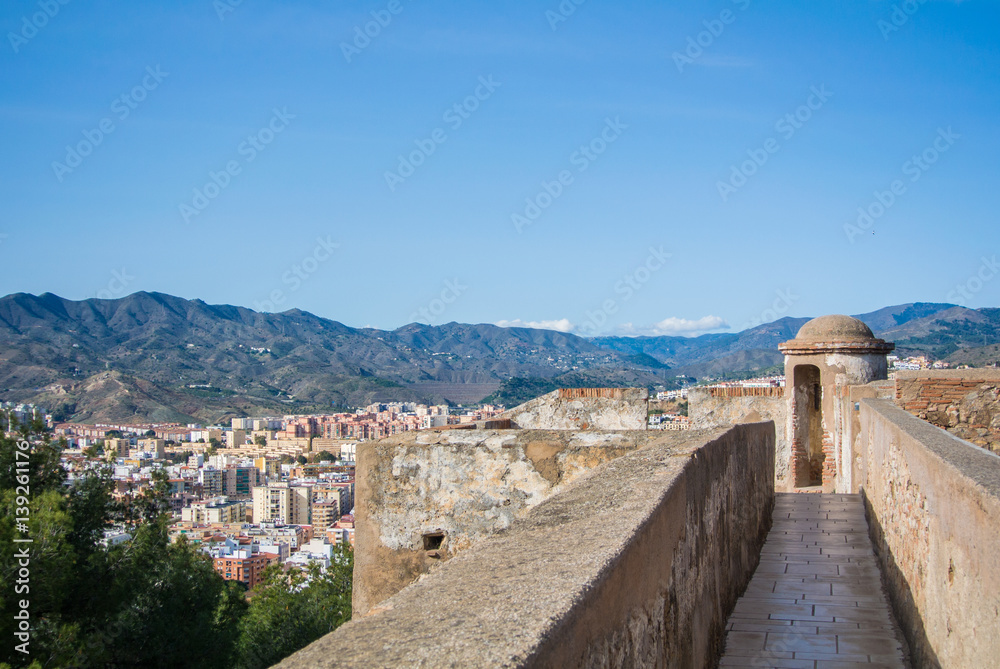 A view from Alcazaba, a fortress of Malaga, to city and surroundings with mountains at the background, Andalusia, Spain. A view from Alcazaba, a fortress of Malaga, to city and surroundings with mountains at the background, Andalusia, Spain.