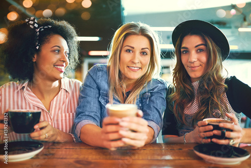 Three trendy young women enjoying coffee © Flamingo Images