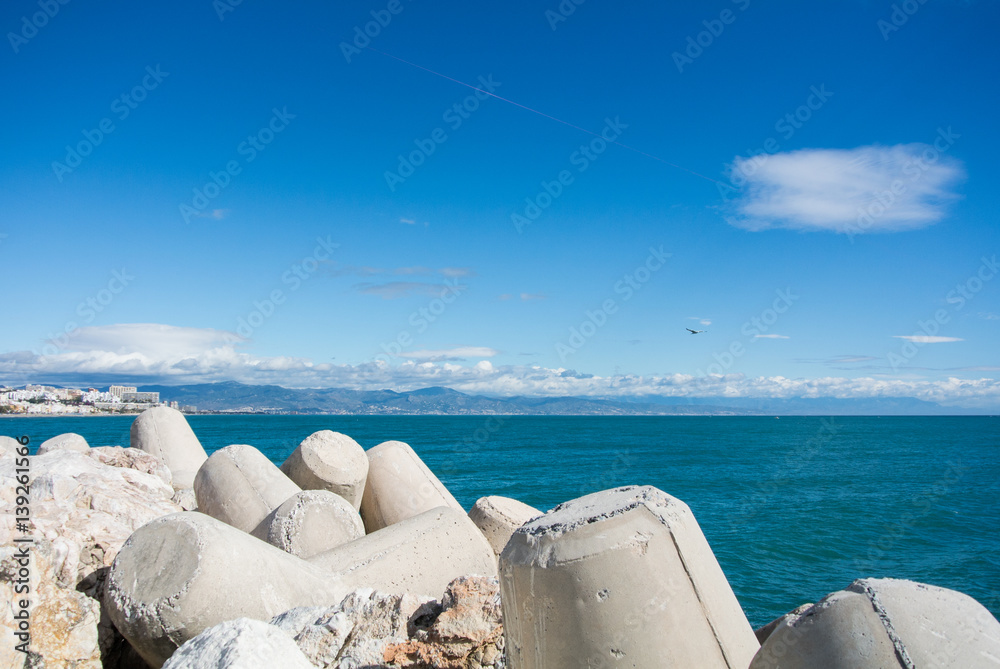 A view to Maditerranean sea and Torremolinos from a pier at Benalmadena port, Andalusia, Spain. A view to Maditerranean sea and Torremolinos from a pier at Benalmadena port, Andalusia, Spain.