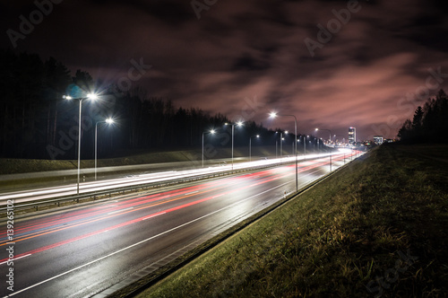 Long exposure shot of highway / motorway at night / road / with led lights - city in the distance / Vilnius bypass