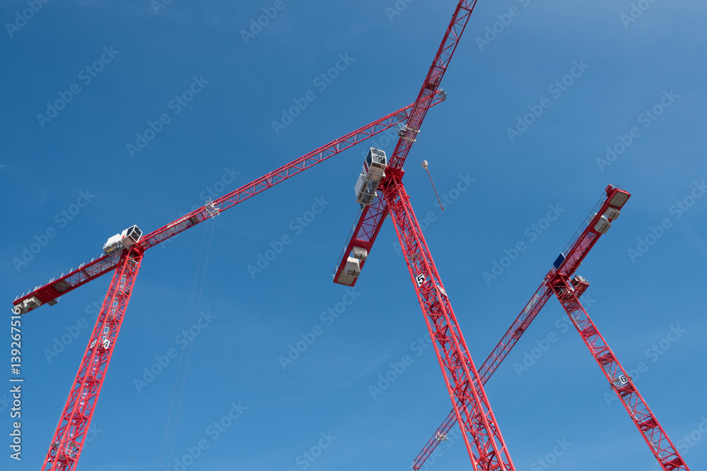red construction cranes on blue sky red construction cranes on blue sky