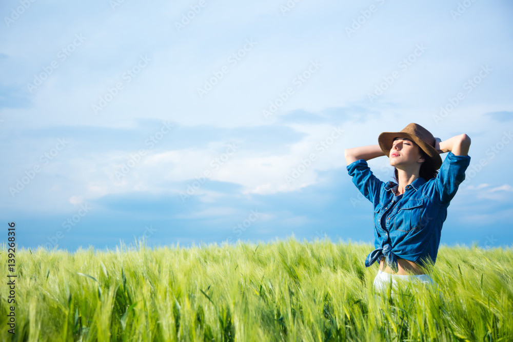 beautiful young woman standing in the middle of the wonderful green field