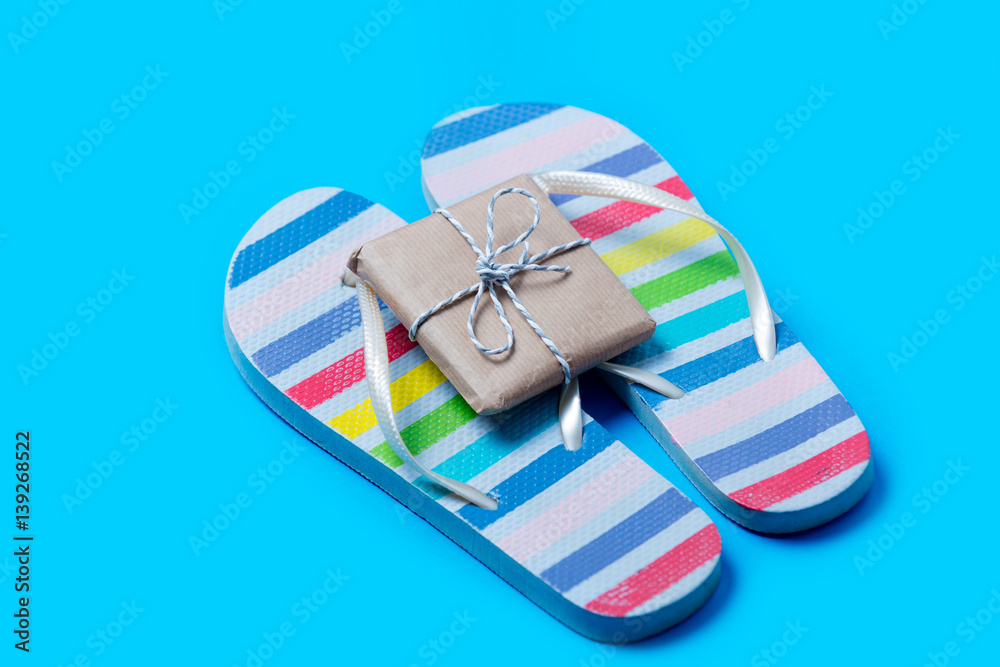 colorful sandals and cute small gift on the wonderful blue background colorful sandals and cute small gift on the wonderful blue background