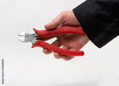 Nippers in the hands of a businessman on a white background