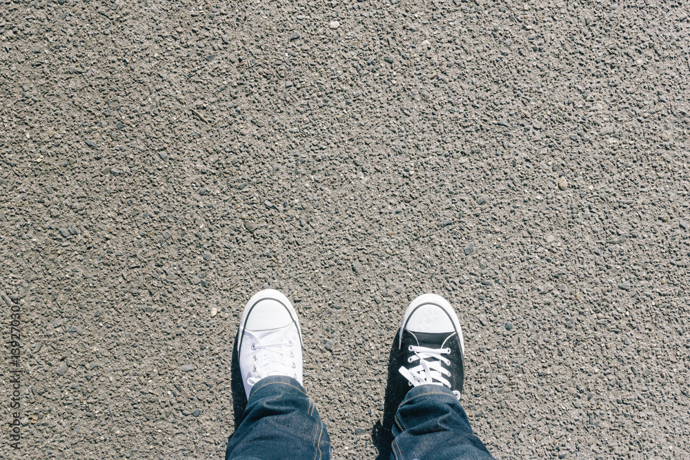 Black and white shoes on asphalt, high angle Black and white shoes on asphalt, high angle