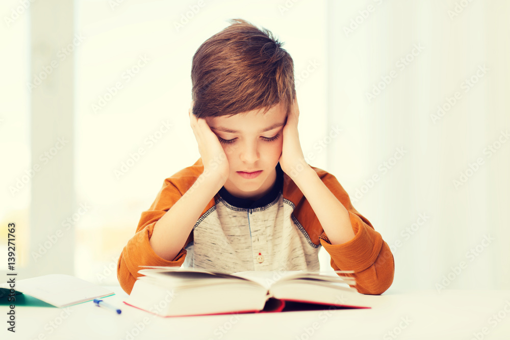 student boy reading book or textbook at home student boy reading book or textbook at home