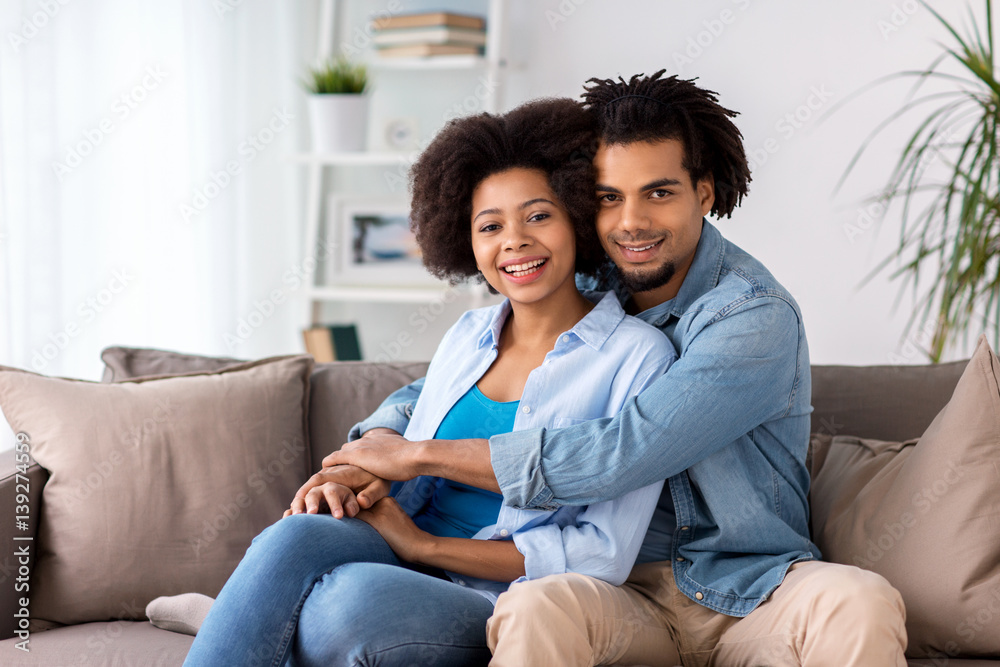happy couple sitting on sofa and hugging at home happy couple sitting on sofa and hugging at home