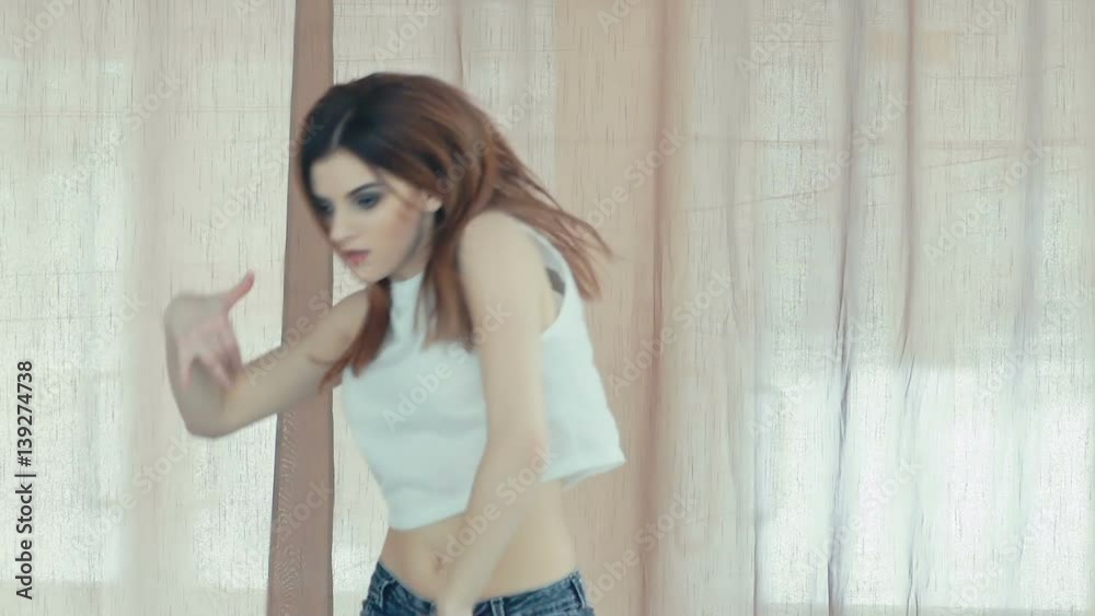 Young pretty girl dancing hip-hop in dance studio. Slowly