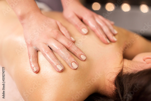 close up of woman having back massage at spa