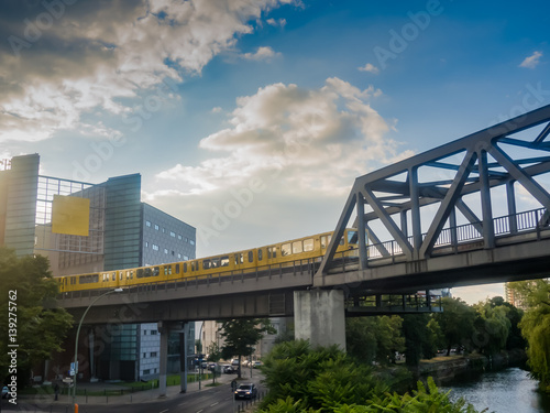 Canvas Print A yellow U-Bahn train is driving through houses of Kreuzberg, in Berlin