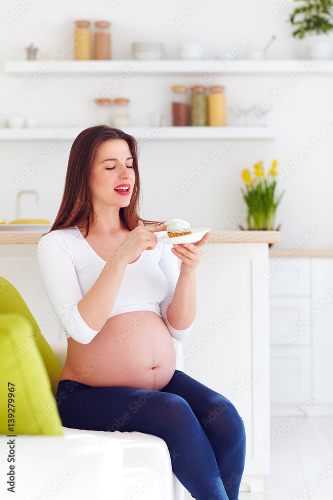 beautiful pregnant woman eating tasty sweet cakes at home beautiful pregnant woman eating tasty sweet cakes at home